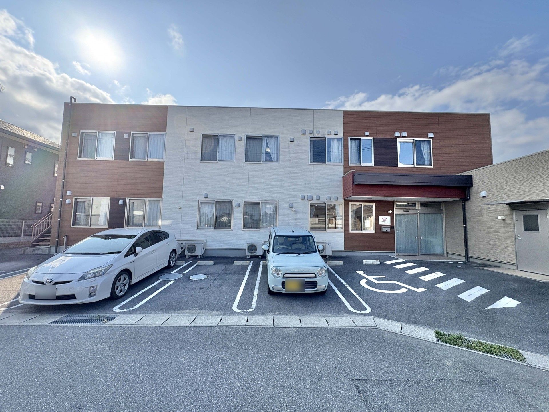 車椅子に座った高齢女性と笑顔で寄り添う女性ヘルパー