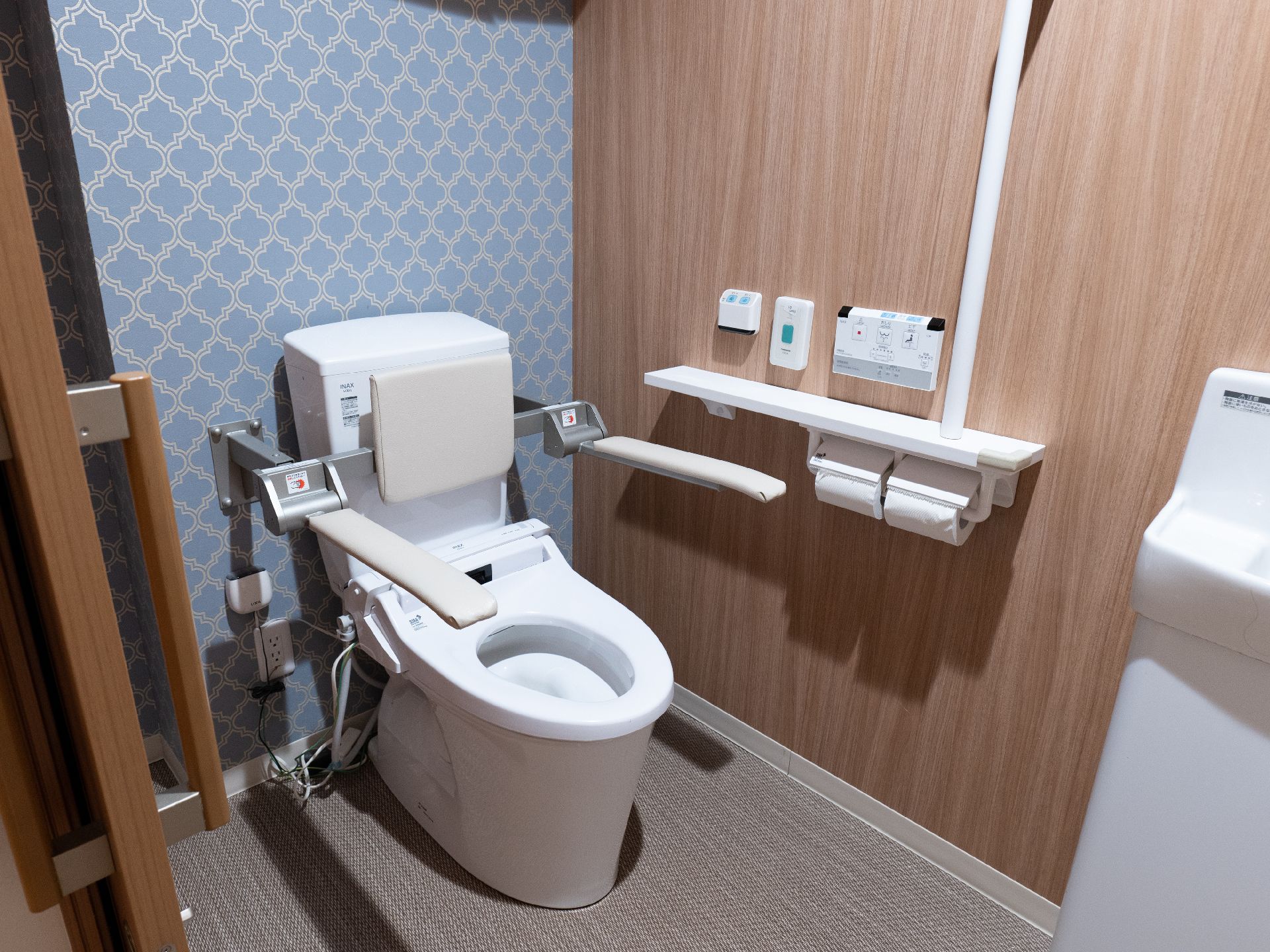 高齢者でも楽に座ることが可能な、手すりのついたトイレ