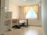 ベッドサイドには緊急通報装置が付いた居室。黄色のカーテンが付いた窓があり、手前には洗面所も設置されている。