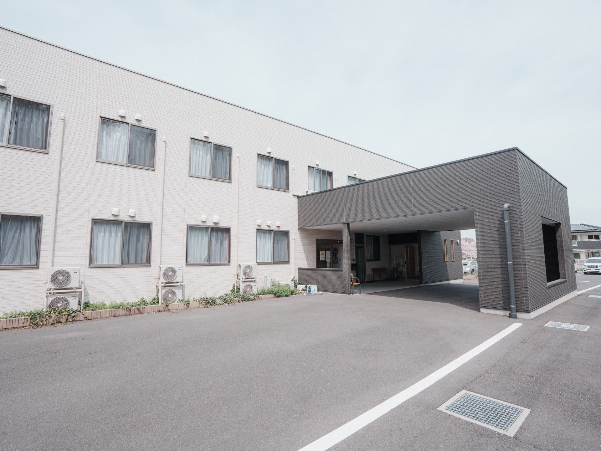なにかを指さして笑顔で話している車いすの女性とそれを押している介護スタッフの様子