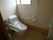大きな手すりが設置された広いトイレ。壁にはトイレットペーパーホルダーや操作パネルも付いている。