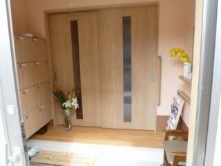 大きな靴箱やいすが設置された玄関には季節の花があちこちに飾られ、陽の光が入っている。