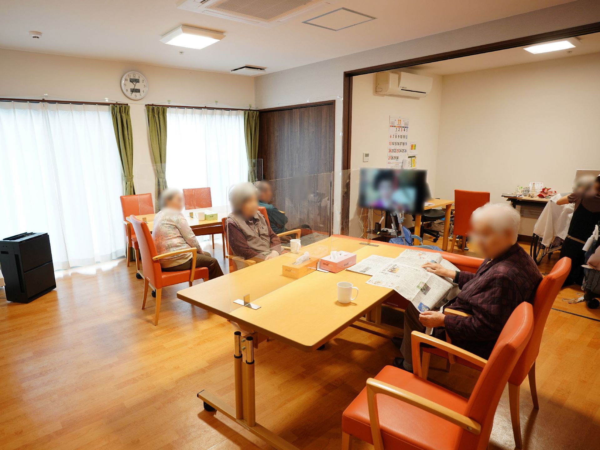 入居者が座って新聞を読んている様子のリビングダイニング