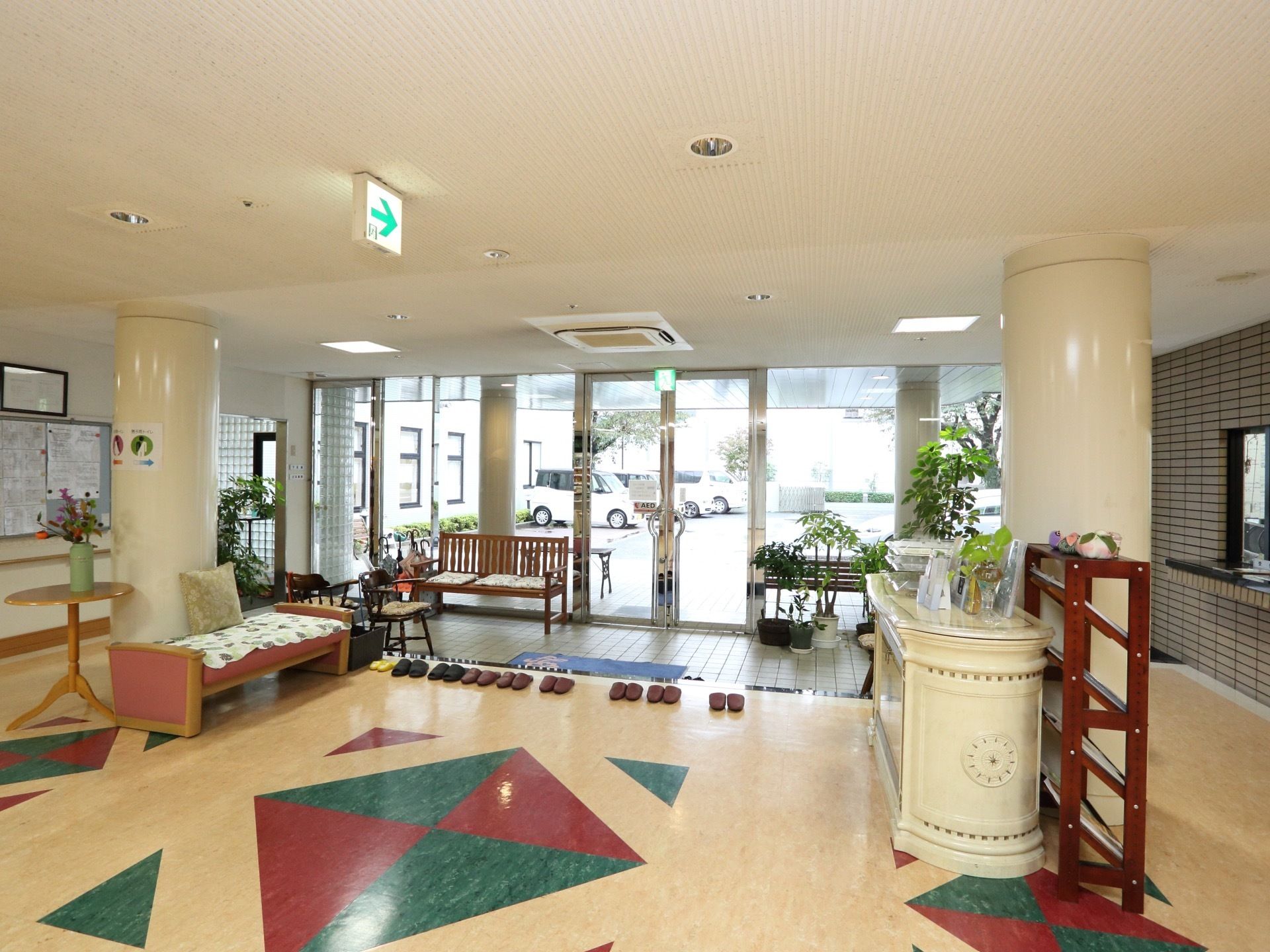 施設の玄関口を館内側から見たところ。休憩用のベンチやソファがあちこちに配置されている。画像右には受付がある。