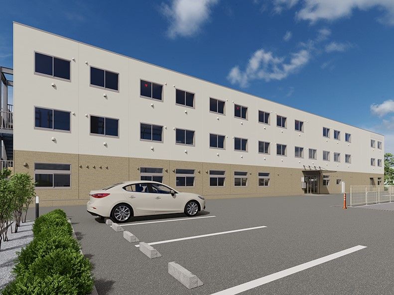 薄茶とベージュの外壁の3階建て建築物