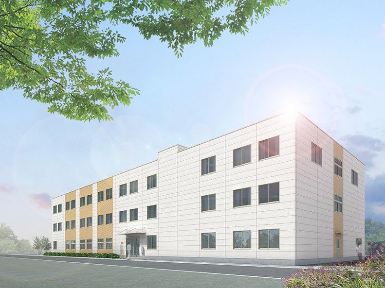 白と薄茶色のツートンカラーの外壁の3階建て建築物