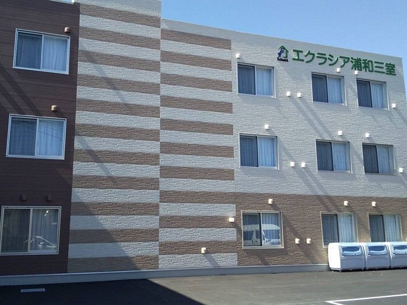 エクラシア浦和三室と書かれている茶色と白の外壁の2階建て建築物