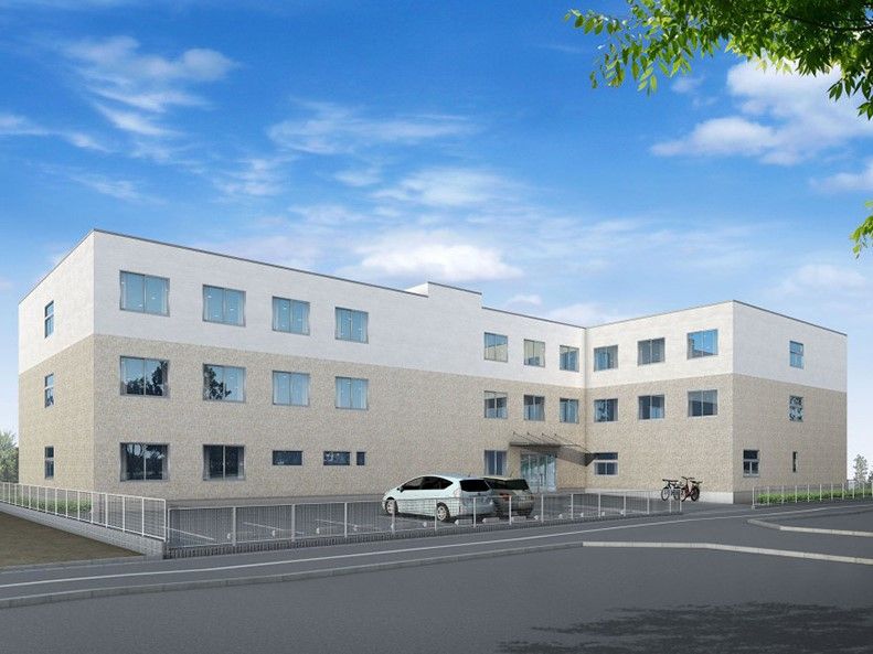 薄茶とベージュの外壁の3階建て建築物