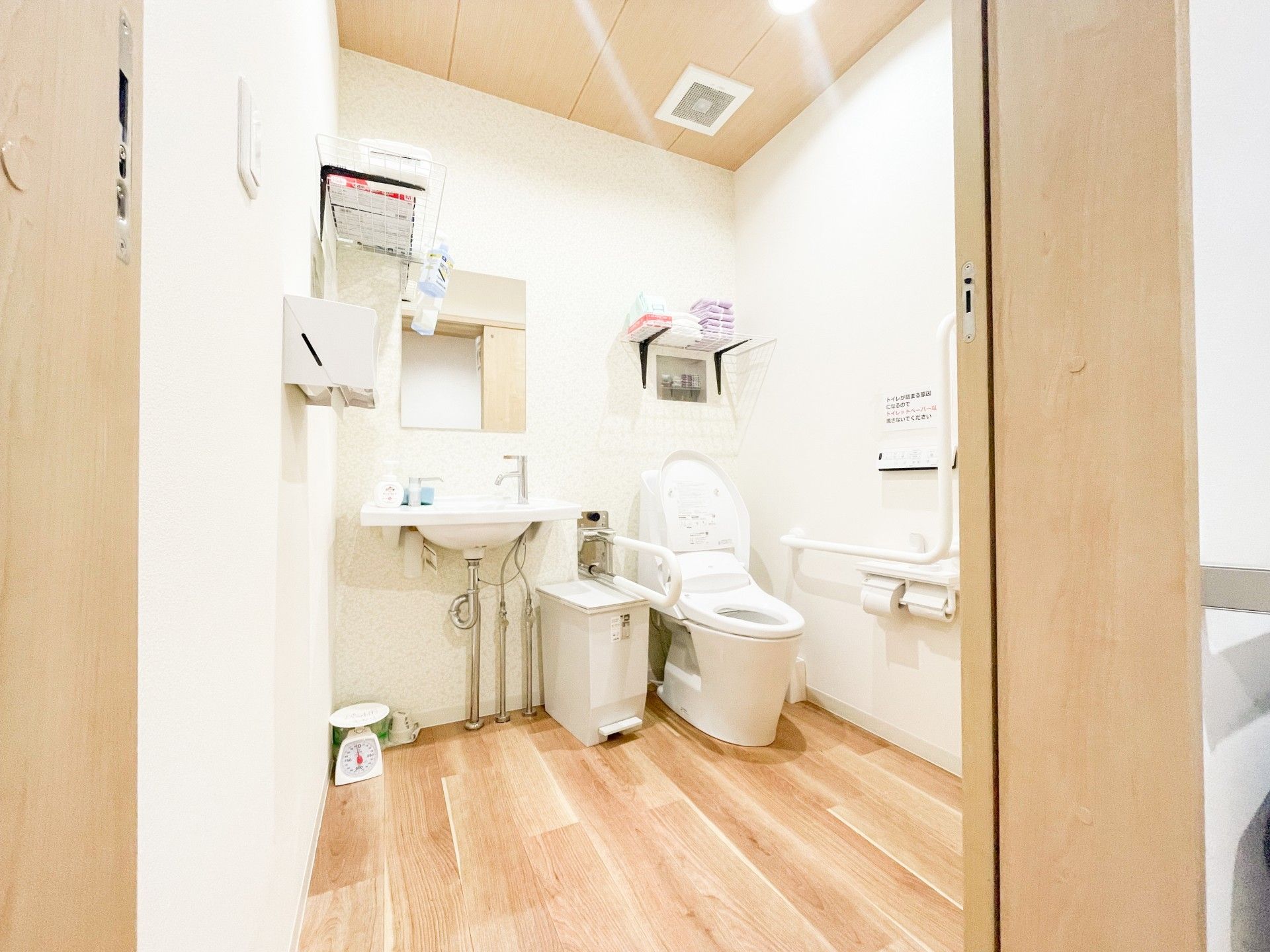 広いスペースが確保されたトイレである。温水洗浄便座が採用されており、操作ボタンが壁に取り付けられている。