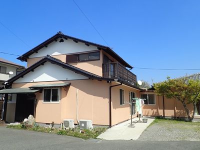 2階建て他の建物には三角屋根が付き、玄関にも小さな屋根がある。敷地内には木が植えられた庭があり、洗濯物干し場には洗濯物が干されている。