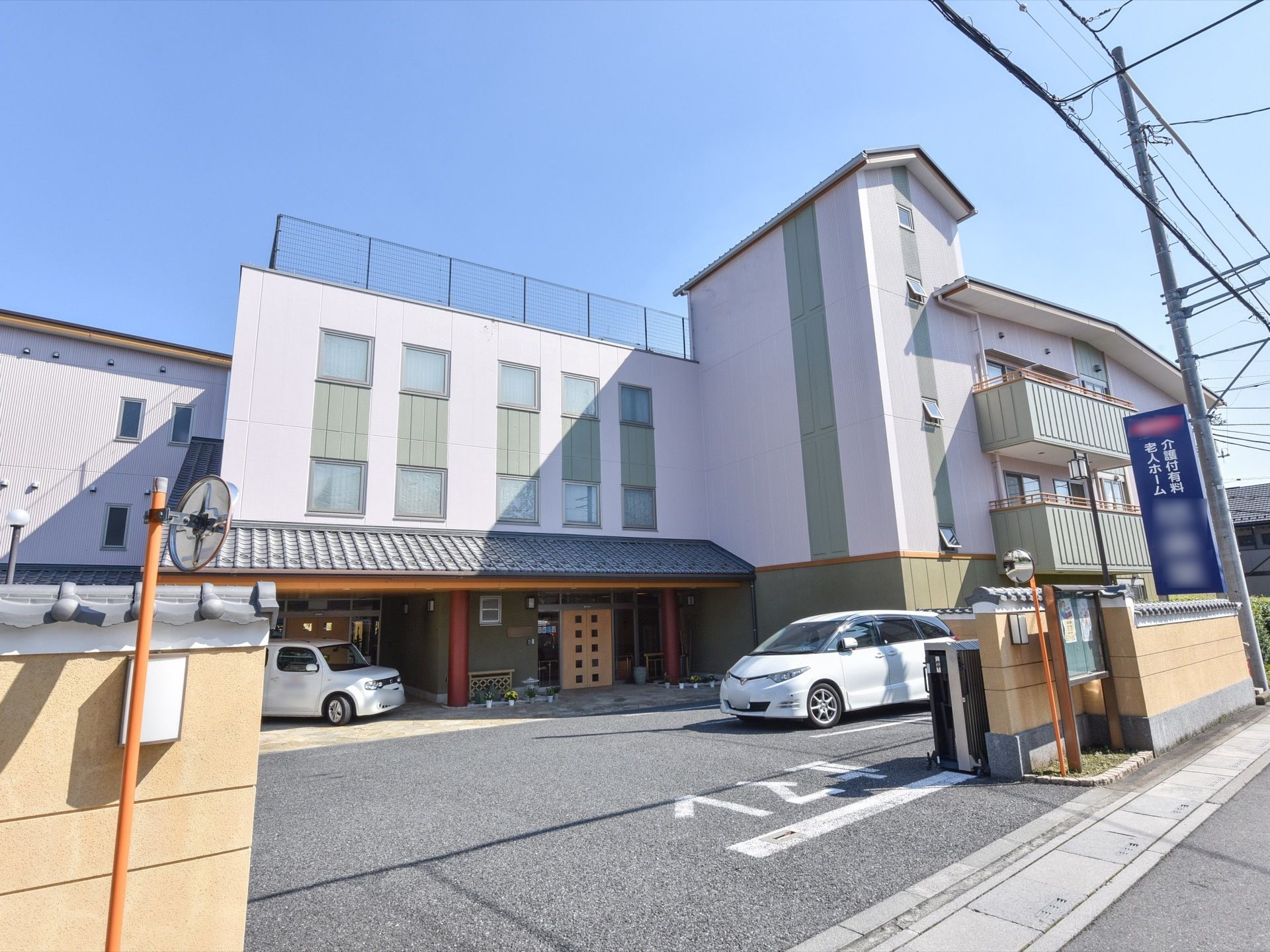 車の入り口部分、そして建物の上部に施設名の書かれた看板が掲げられている。施設手前には広いスペースが設けられている。