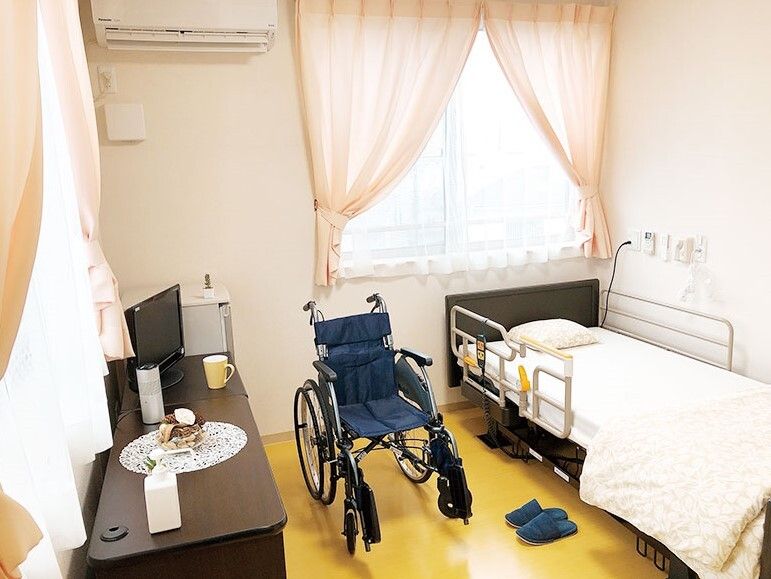 寝具付きのベッドやテレビ、車いす、エアコンなどが設置された段差のない部屋には、大きな窓が二つ付いている。