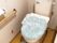 オレンジの呼び出しボタンが設置されたトイレには手すりもあり、便座にはカバーがかけられている。