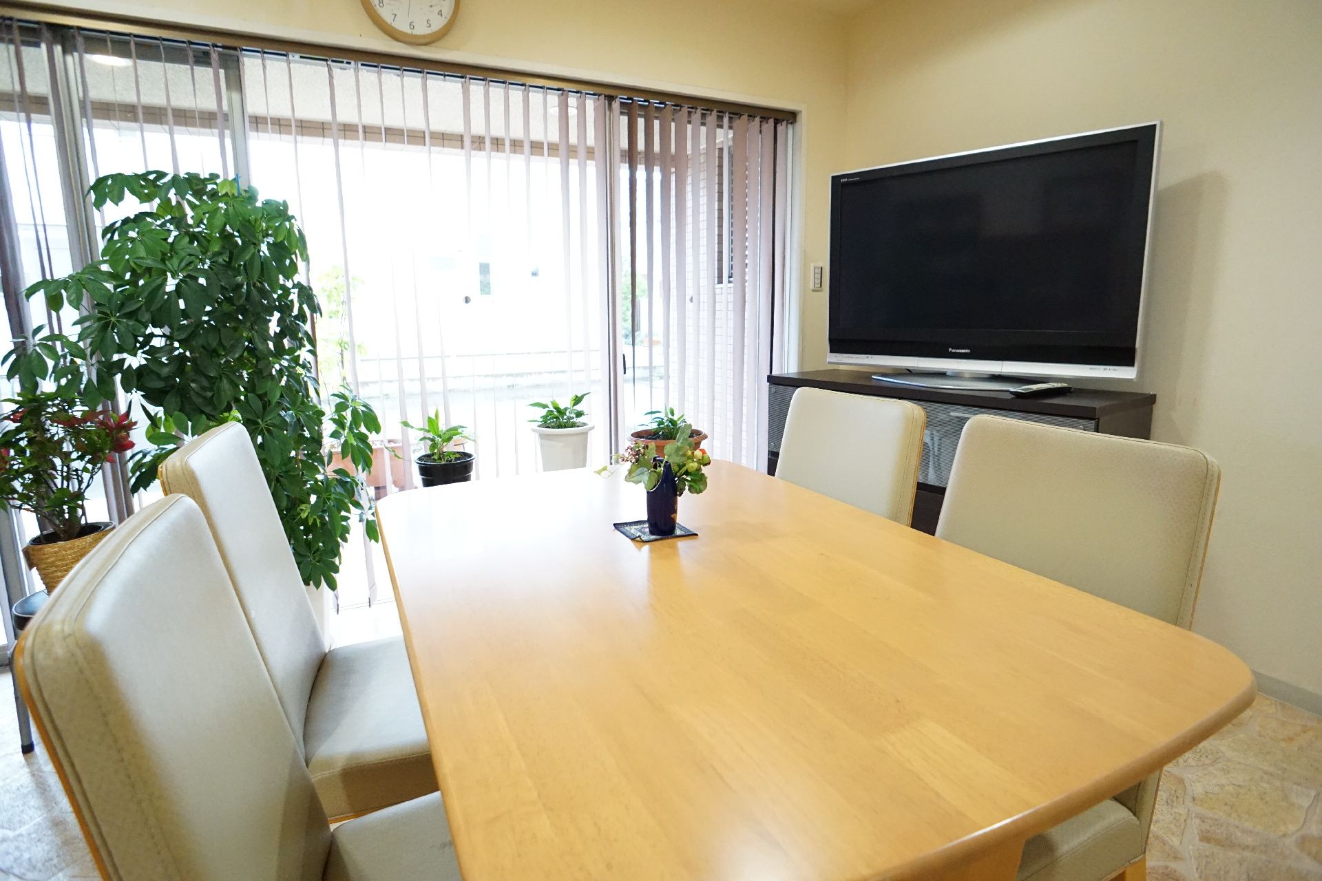 壁沿いにテレビが配置された大きな窓ガラスのある部屋