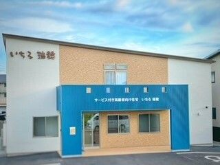 屋根が斜めの平屋の建物。青と白と茶色のカラーリングだ