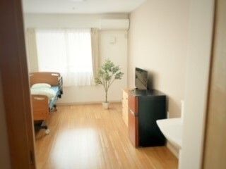 窓から光が入り、介護ベッドと収納が置かれている居室