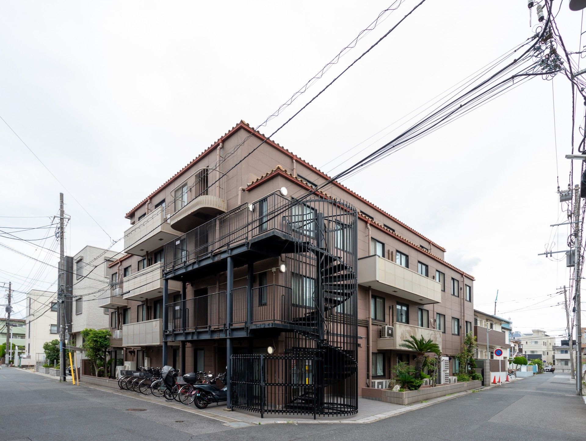 ストライプ柄のシャツを着た高齢男性が福祉車両から下りようとしていて、男性の手を支えサポートしている若いエプロン姿のスタッフがいる。