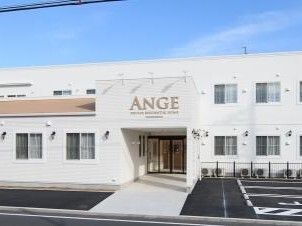 白を基調と階建ての建物は横に長く、敷地内には駐車場もある。建物の周りには緑の低木が植えられ、玄関の屋根にはホーム名が書かれている。