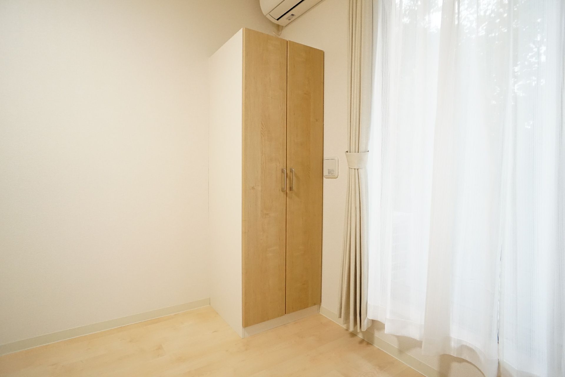 ブルーのユニフォームを着た男性スタッフと高齢女性が並んで座り、女性は赤いロープを引っ張っている。