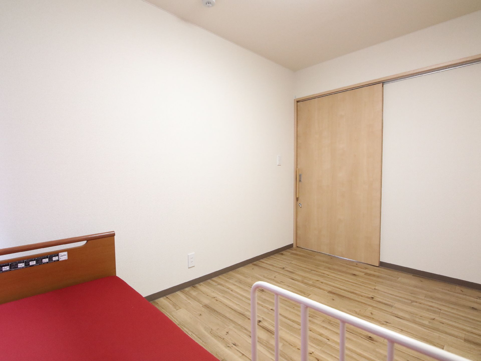 窓から日差しが入り、介護ベッドが置かれている居室