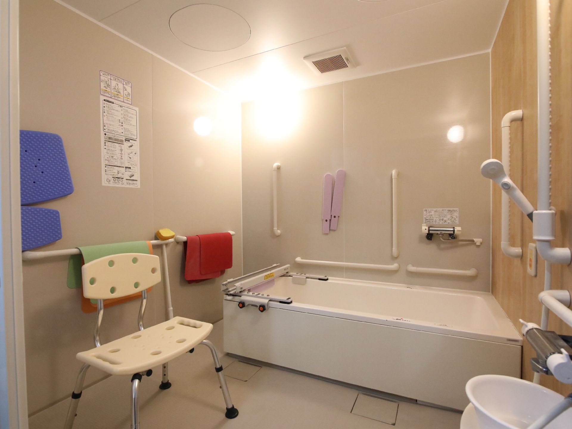 手すりが取り付けられ、落ち着いた色合いの浴室