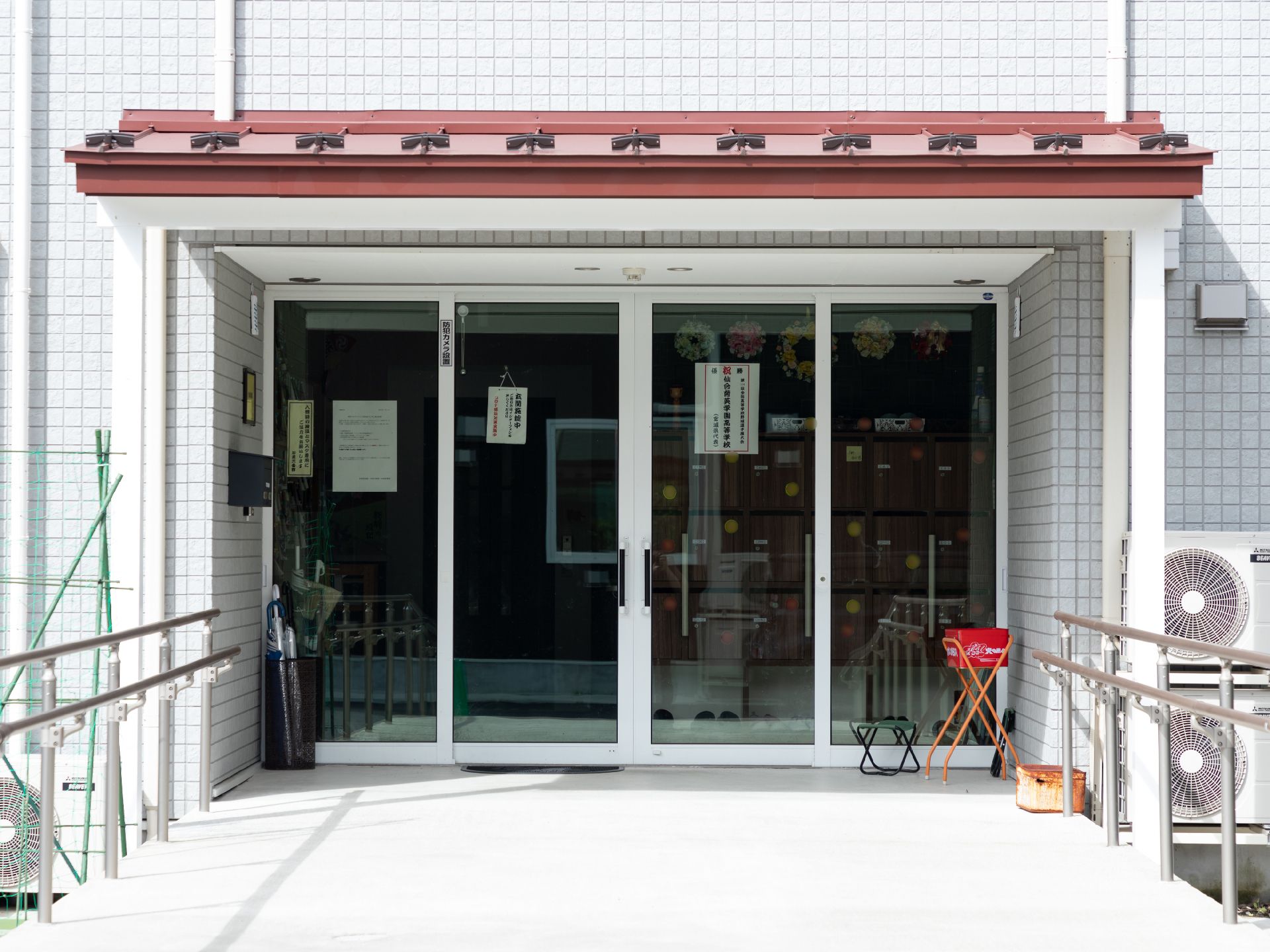 車いすの高齢者と手を握りながら話す介護スタッフの様子。施設内での会話の場面