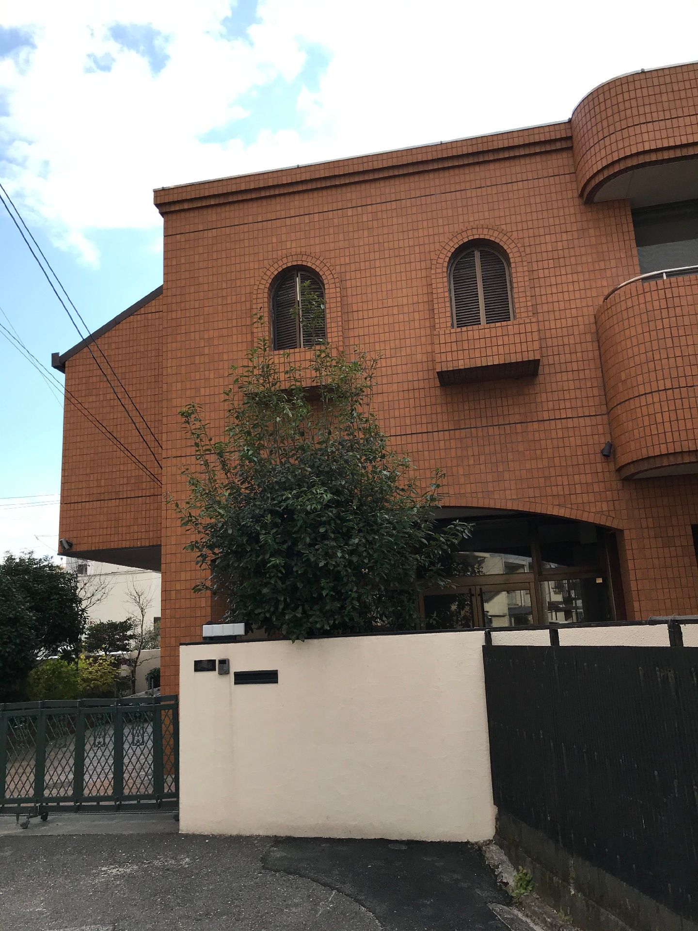 シックな色の壁が印象的な施設外観。洋風の窓がある建物