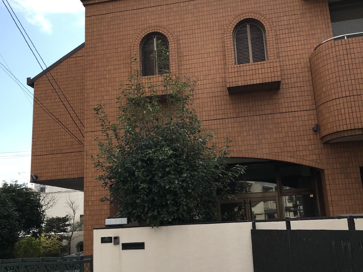 シックな色の壁が印象的な施設外観。洋風の窓がある建物