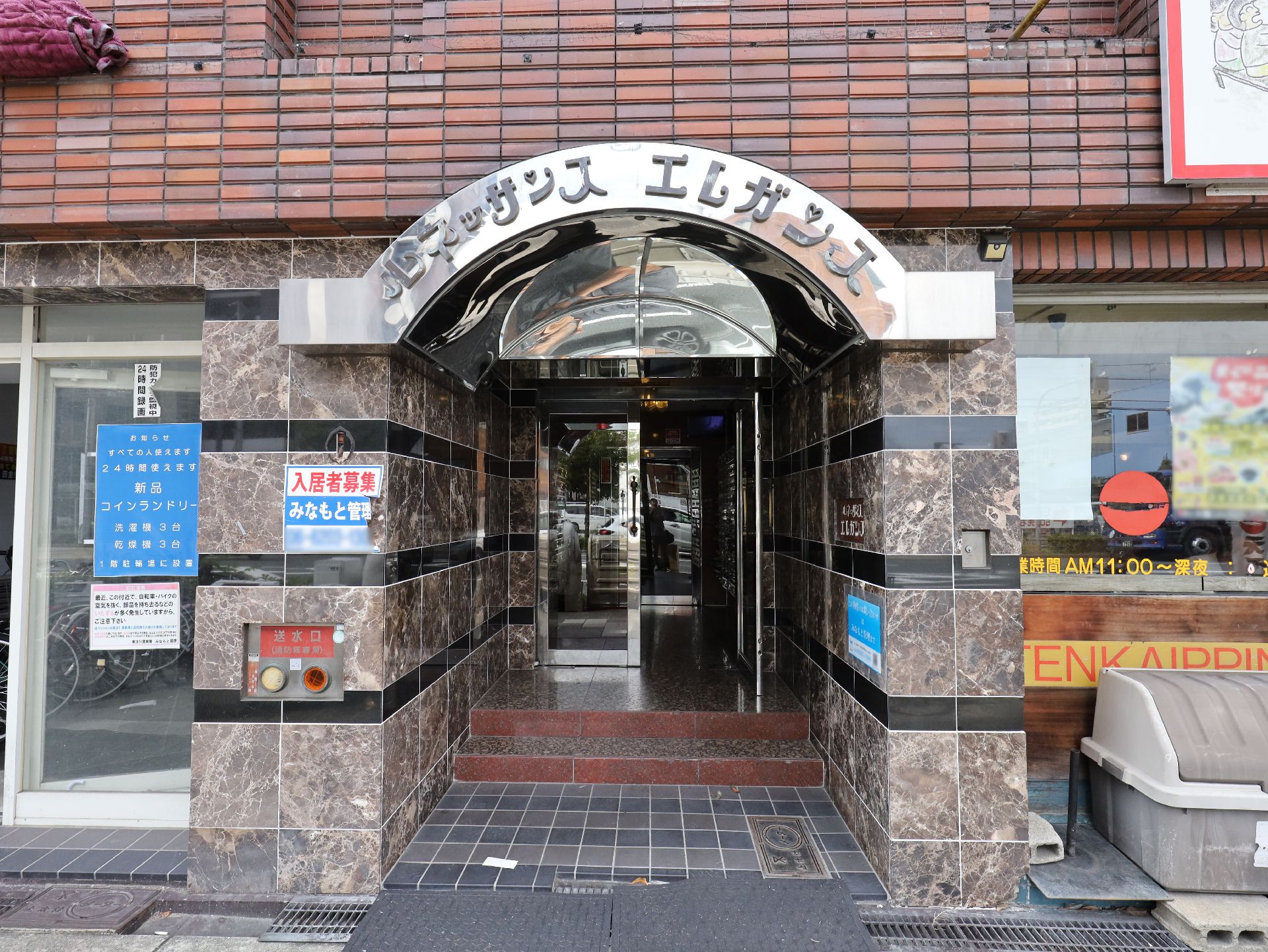車いすに乗った女性を押す家族の男性とそこに寄り添う介護スタッフの様子