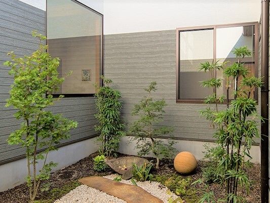 石が置かれていたり、気が植えられたりしている和風の中庭。建物には大きな窓がたくさんつき、窓から中庭を見ることができる。