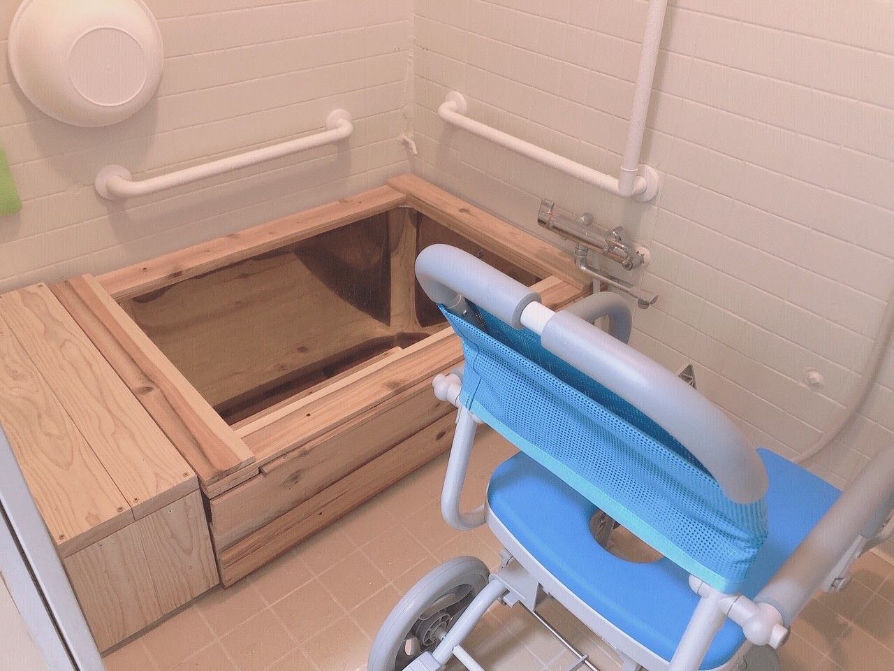 青いシャワーチェアが設置されている浴室