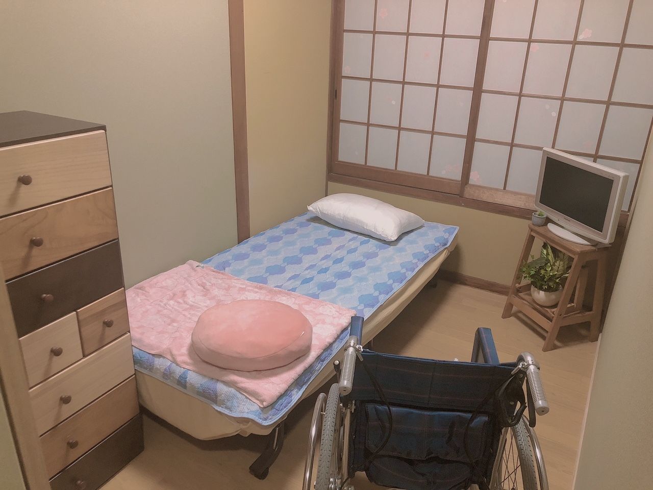 ベッドやタンスが設置され障子の戸が付いている和風の居室