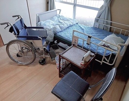 スタッフと高齢者が話している様子。カルテのようなものを書いている場面