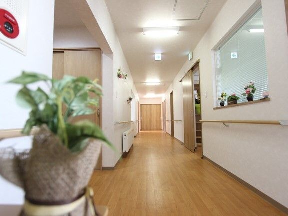 手すりが設置された廊下にはパネルヒーターがあり、右側には階段もある。
