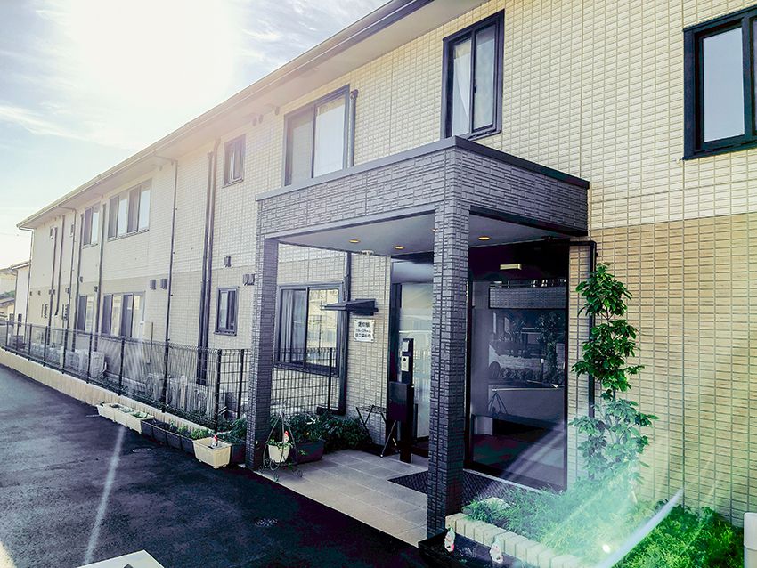 日当たりのいい場所に建っている２階建ての建物は横に長く、玄関には車寄せが付いている。