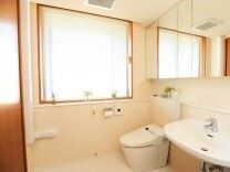 広い白を基調としたスペースにはトイレと洗面所があり、壁にはオレンジの呼び出しボタンがある。