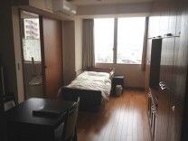 フローリングの部屋には大きな窓があり、寝具付きのベッド亜が置かれ、エアコンも付いている。