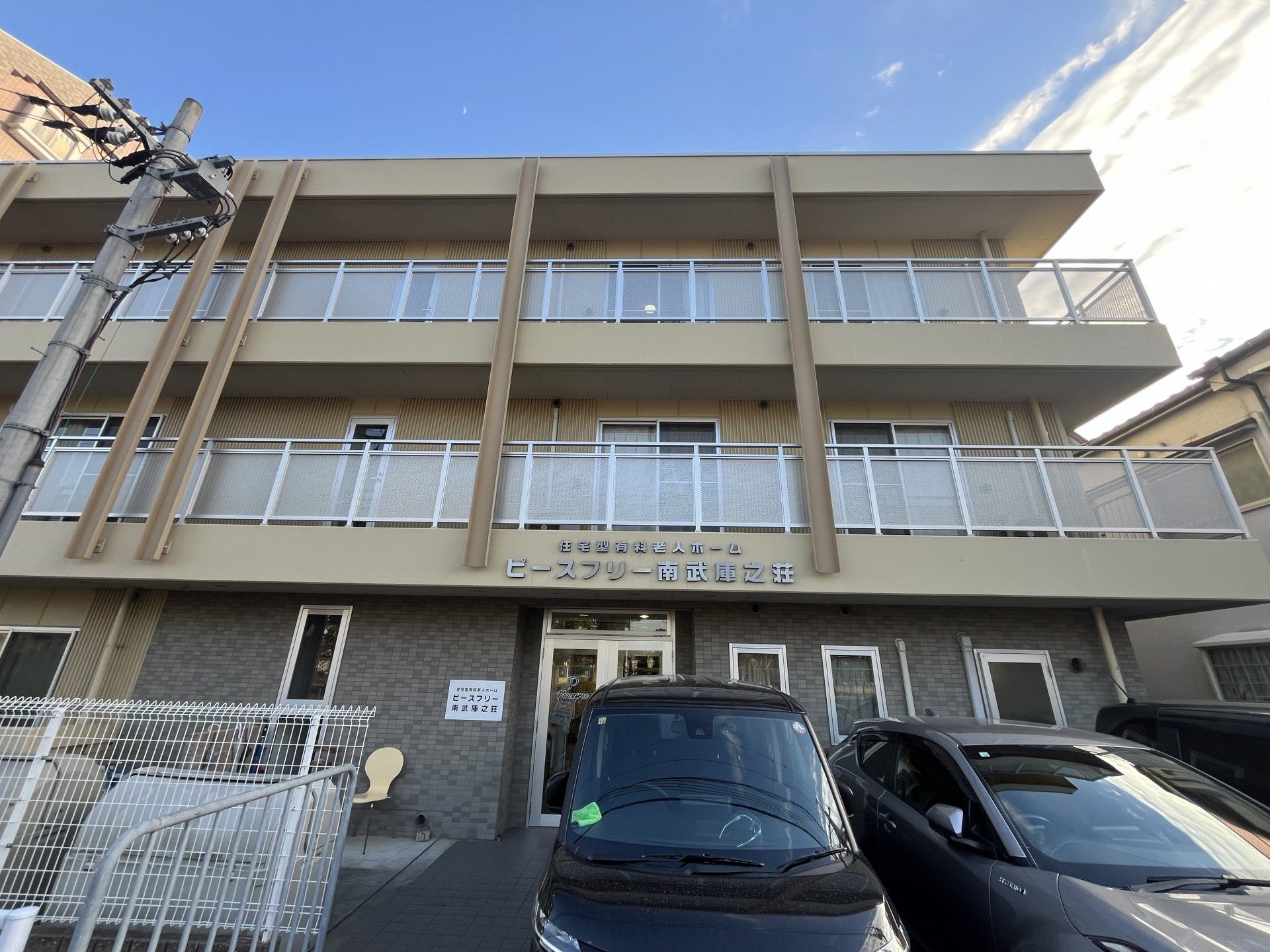 車いすに乗った女性を押す家族の男性とそこに寄り添う介護スタッフの様子