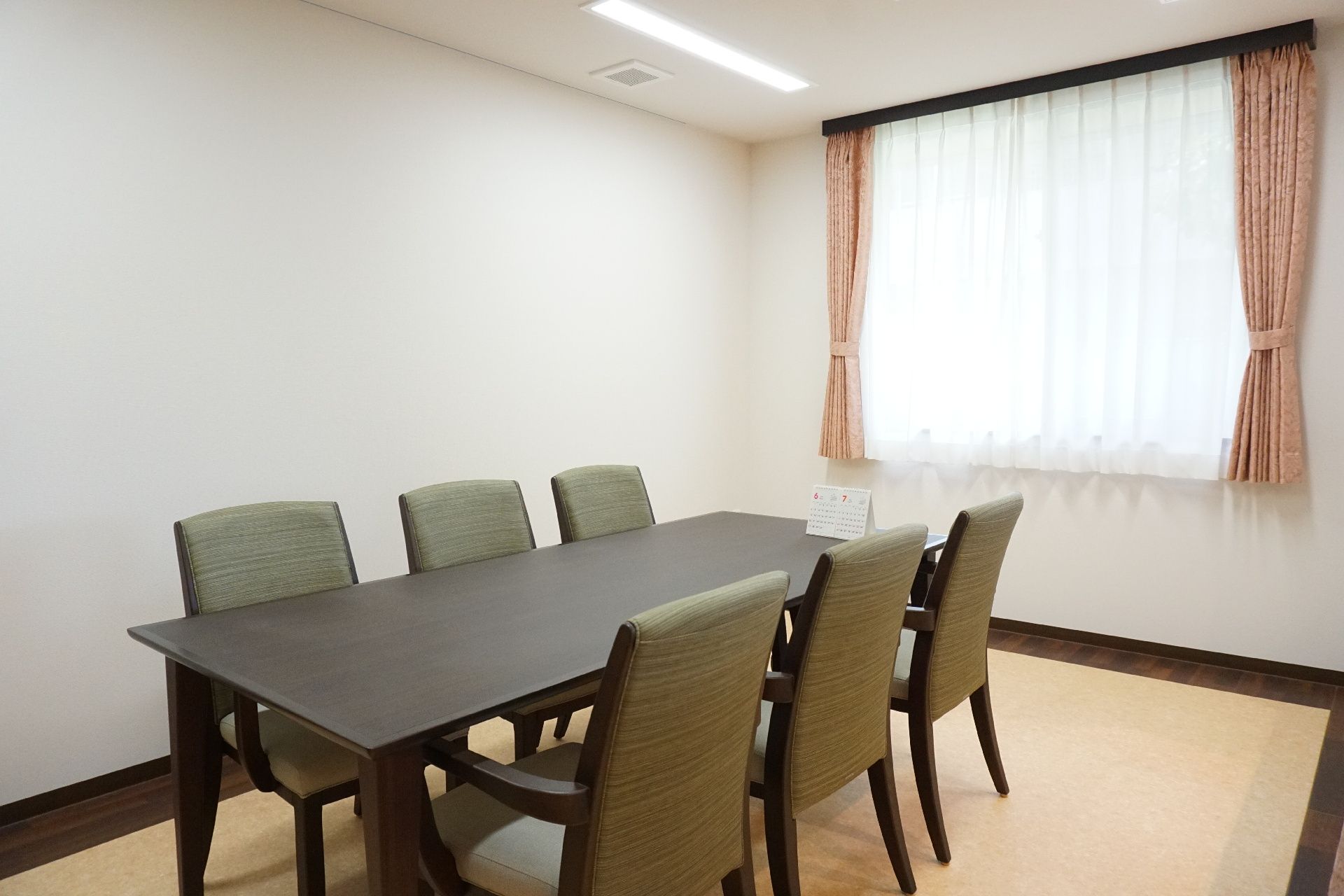落ち着いた色合いのテーブルを挟んで、椅子が設置されている部屋