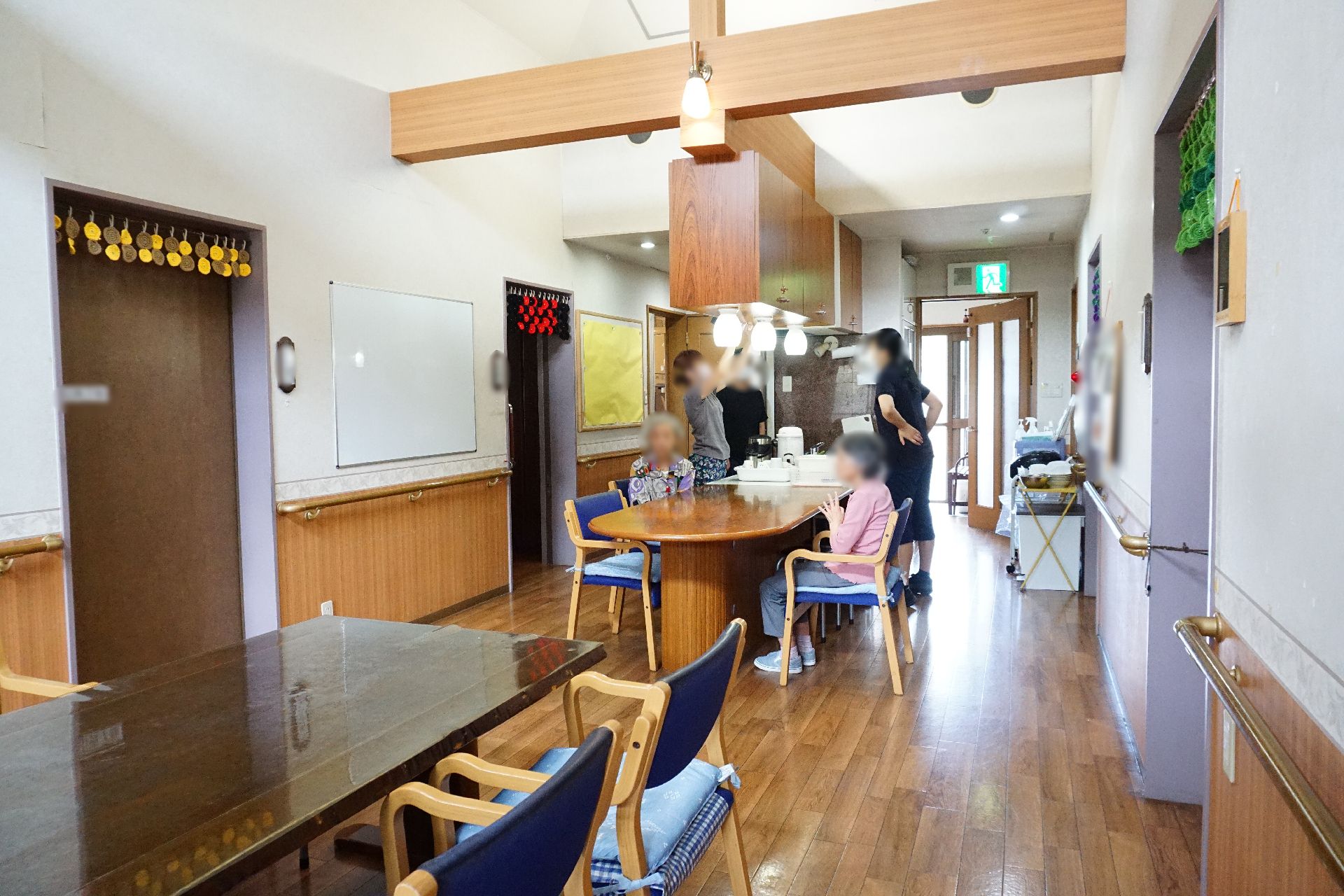 大きなテーブルが2つ設置され、天井に梁が設置されているリビング