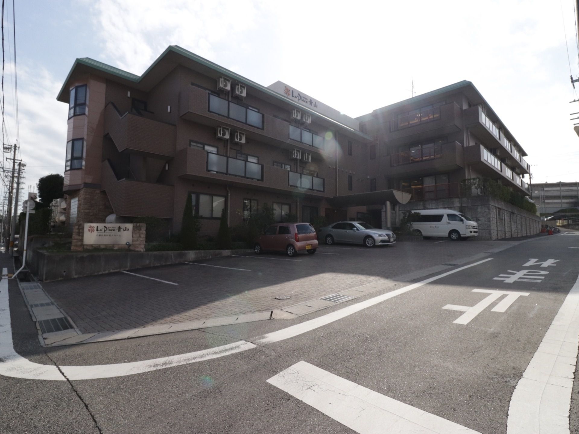 ラ・プラス青山の施設外観。大きな駐車場を完備しております。ご来訪の際はお車でのお越しが出来ます。