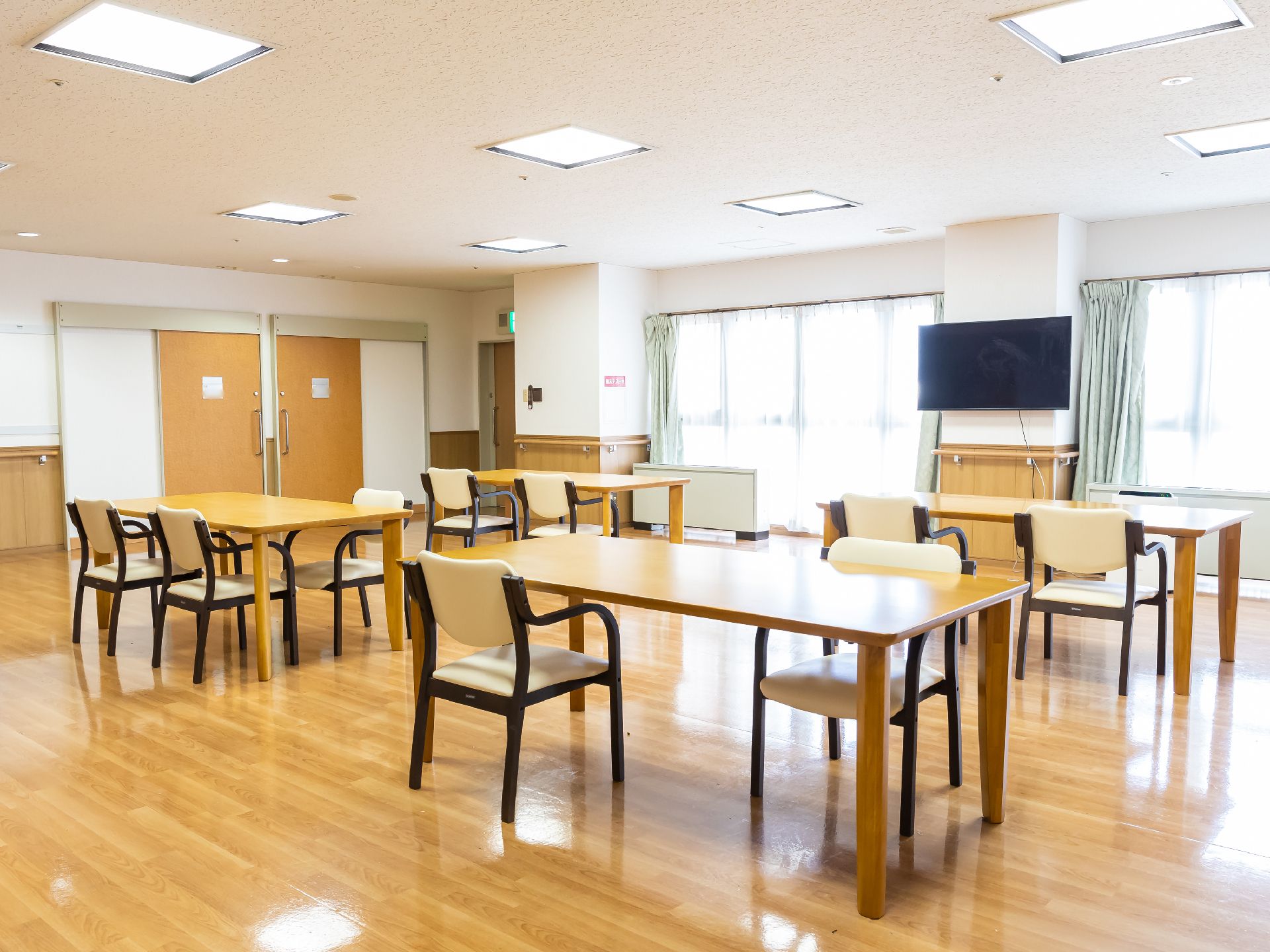 照明が設置され、テーブル、椅子が置かれている共有スペース