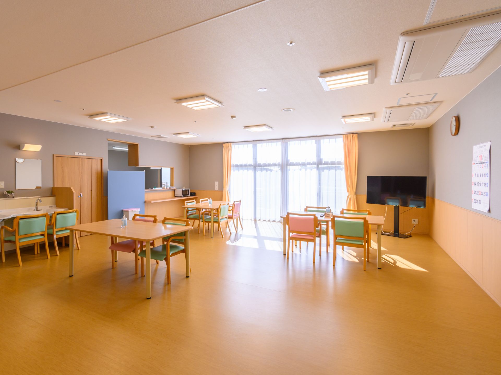 テーブルや椅子、テレビが置かれ、入居者が自由に時間を過ごすことのできる共有スペース