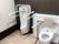 背もたれと手すり付きのトイレと男性用の小便器が設置されている。
