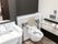 呼び出しボタンが設置された広いトイレには背もたれと手すり付きのトイレがある。