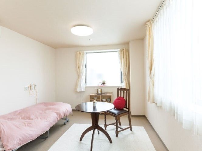 こじんまりとしたワンルームタイプの部屋。ベッドや調度品が置かれている部屋の様子