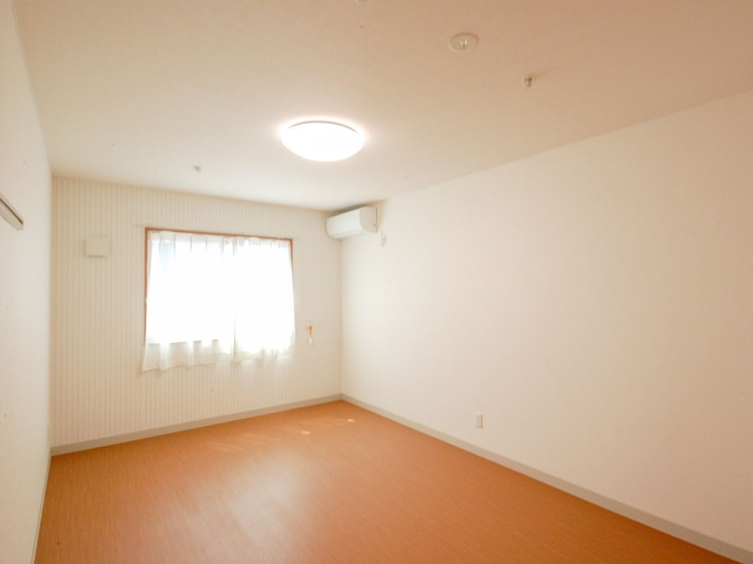 エアコンや緊急通報装置が設置された部屋はフローリングで大きな窓があり、家具などは置かれていない。