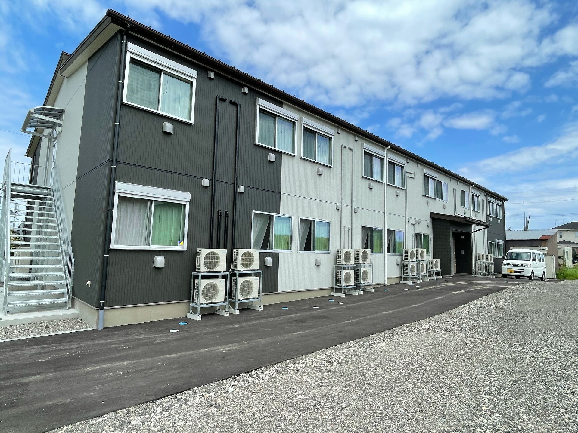 非常階段の設けられたツートーンカラーの2階建ての建物