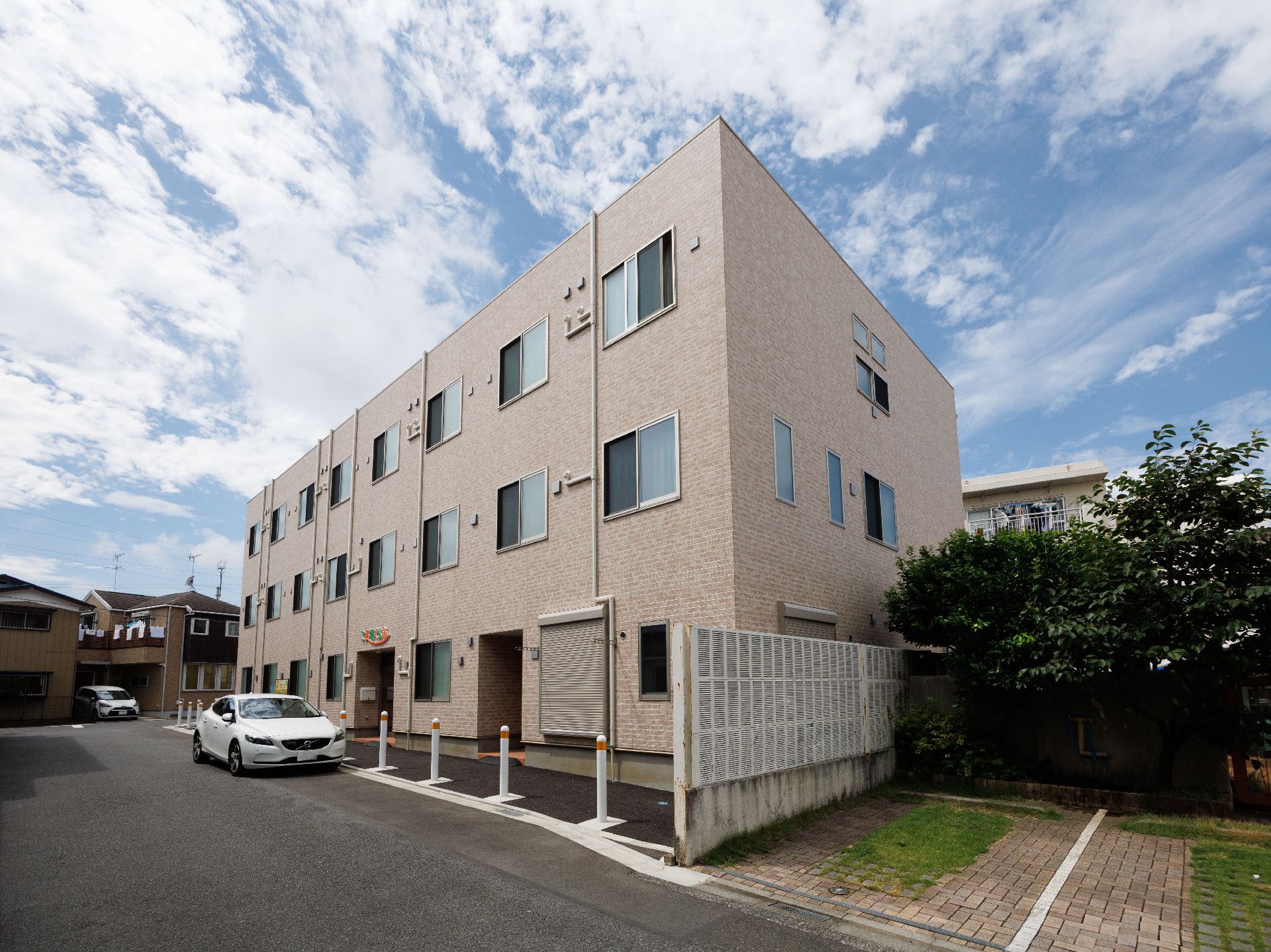 アスファルトの道路沿いに立地している３階建てでベージュの外観の建物