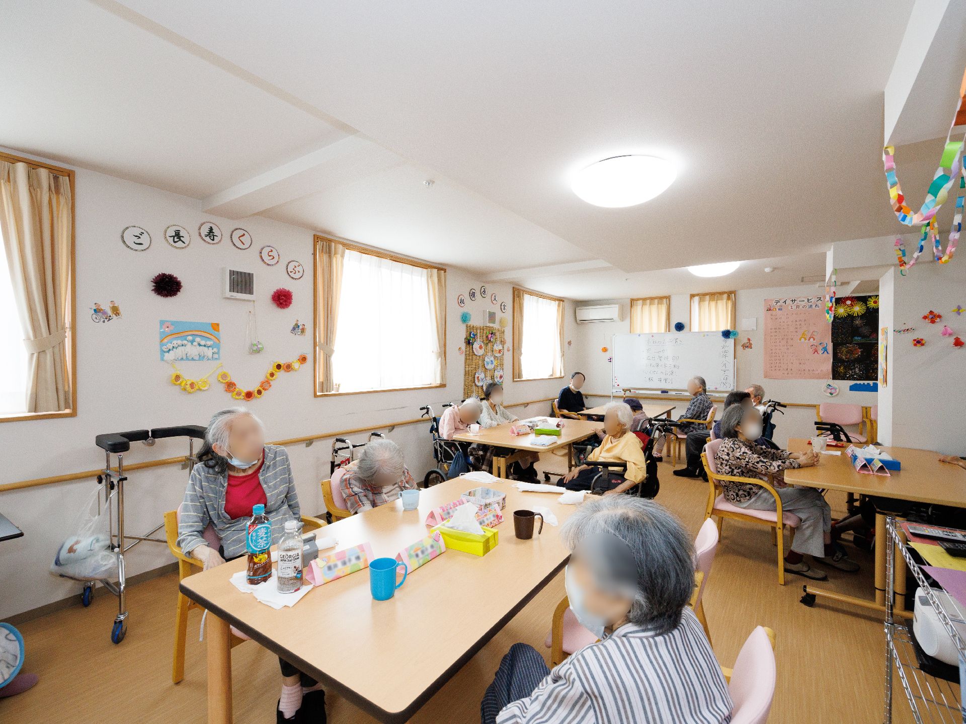 木製の机が置かれた白い壁の広間